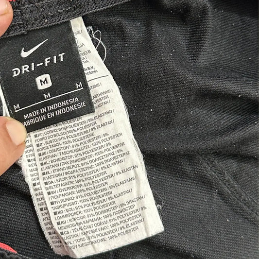 Nike track pants are designed with a bold red stripe along the sides