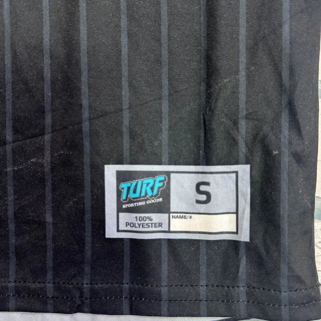 A stylish black jersey tee with a pinstripe design and bold red “Dirty Queens” lettering on the front