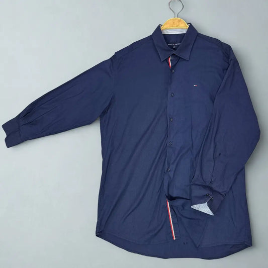 Tommy Hilfiger ®. It comes in a versatile and classic solid navy blue, making it a staple for any wardrobe.