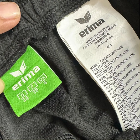 Erima Black Track Pants with striking red side panels and branding.