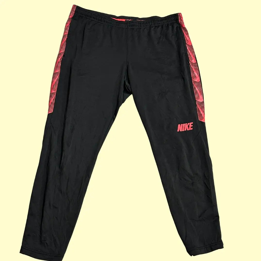 Nike track pants are designed with a bold red stripe along the sides