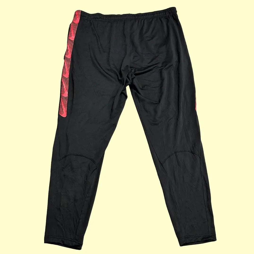 Nike track pants are designed with a bold red stripe along the sides