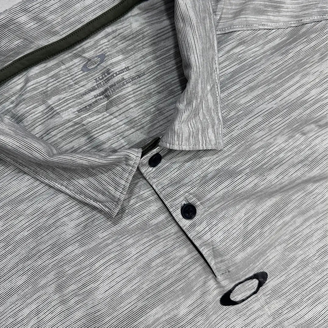 Oakley Performance Polo Shirt in light gray with subtle stripe design.