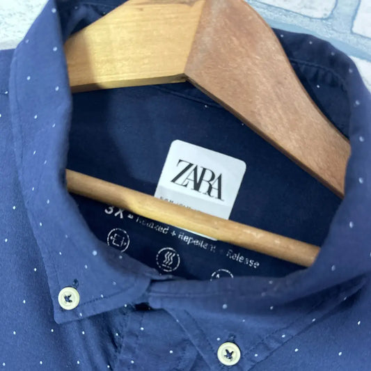 Zara ® It comes in a versatile solid navy blue and features a subtle, all-over white pin-dot pattern, adding a touch of classic refinement.
